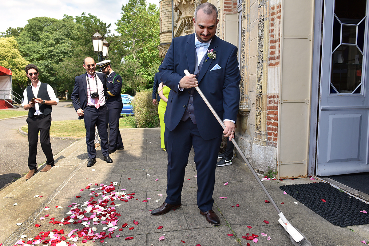 Le marié balaie les pétales tombés sur le sol.