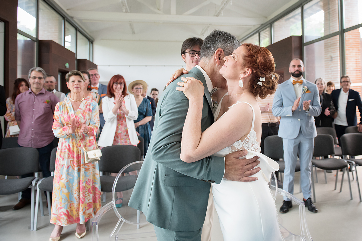 Un couple de m'ariés s'embrassent heureux devant l'autel de la mairie