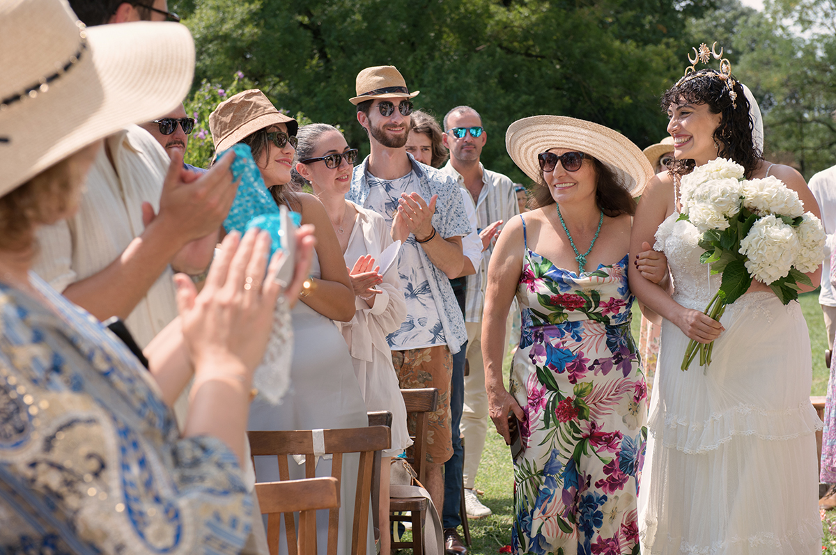 photographe mariage toulouse - la mariée arrive au bras de sa mère pendant la cérémonie laïque.