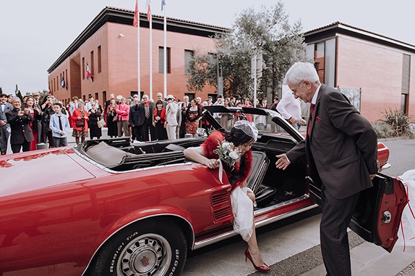 La mariée descend de son cabriolet rouge Arrivée à la mairie de Mondonville près de Toulouse, la mariée descend de la voiture en tant aidée par son père.