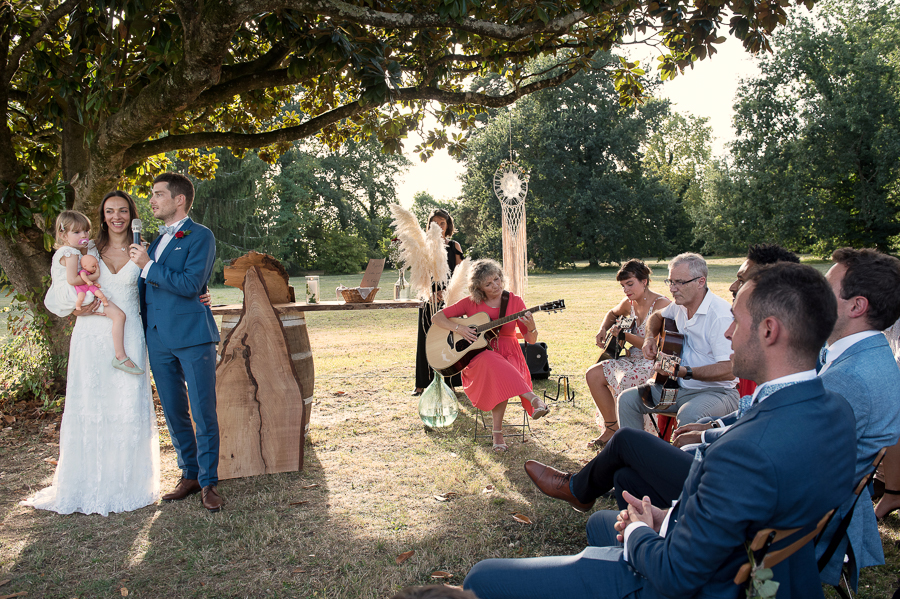 La mère du marié joue de la guitare pendant la cérémonie laïque au château lavalade