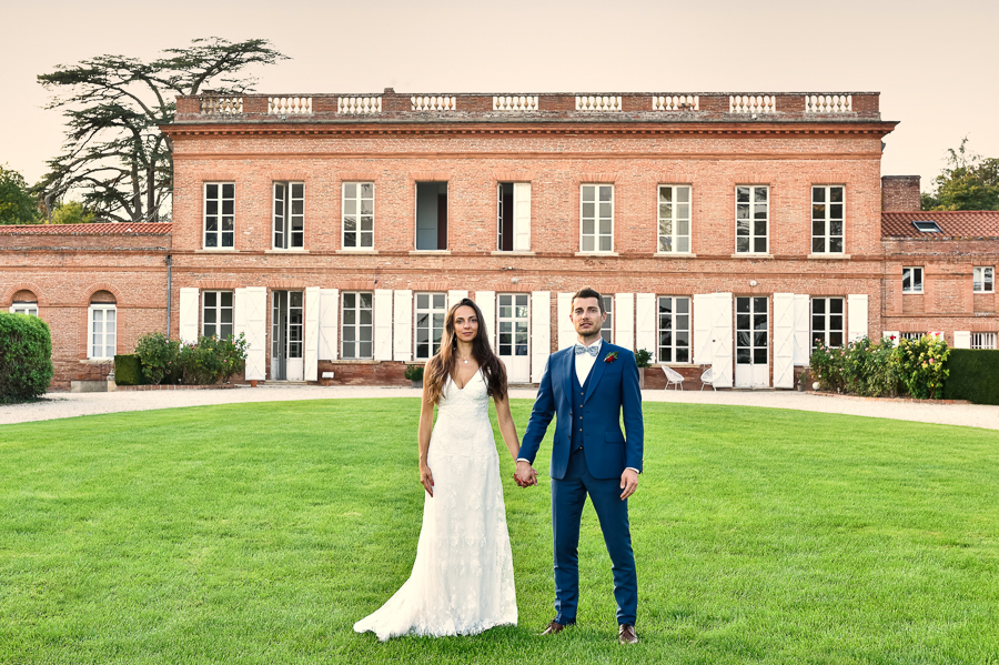 Le couple de mariés, main dans la main,  devant le château Lavalade.